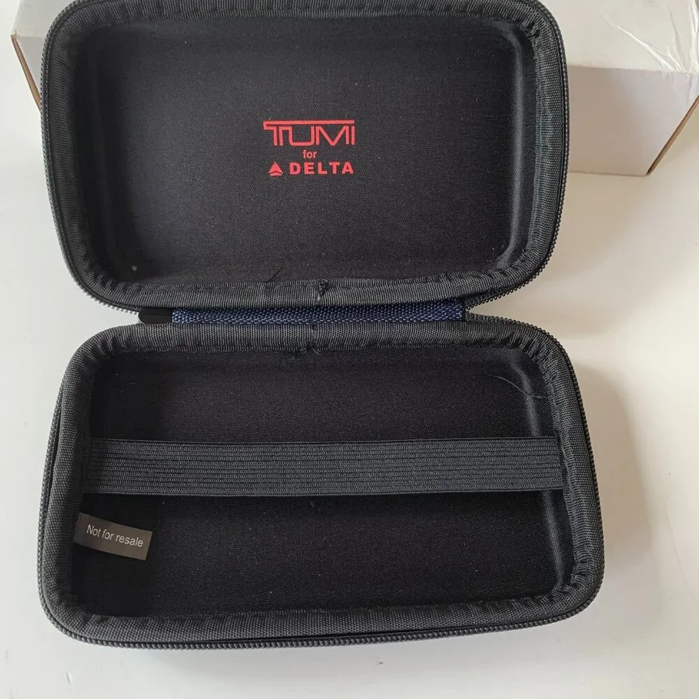 The product is a navy blue hard case amenity kit bag by TUMI for Delta Airlines.
